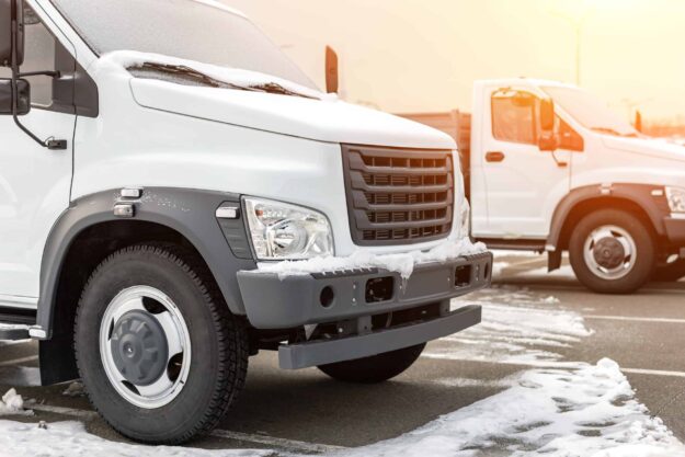 New middle size trucks at dealership parking outdoors at winter. Truck service and maintenance. Delivering and warehouse service